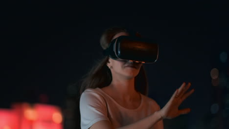 Eine-Junge-Frau-Mit-Virtual-Reality-Brille-Bewegt-In-Der-Nächtlichen-Stadt-Ihre-Hände-Und-Meistert-Die-Anwendungsoberfläche.-VR-Technologien-Der-Zukunft-Im-Alltag.-Virtual-Reality-Spiele